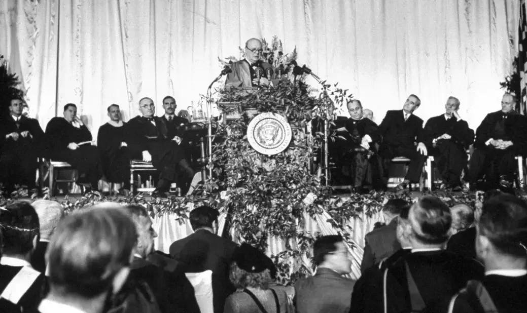 Președintele Truman(în stânga) ascultând faimosul discurs despre amenințarea comunistă al prim-ministrului britanic Winston Churchil
